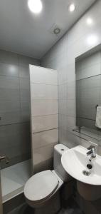 y baño con aseo blanco y lavamanos. en CH Otello Rooms I - Madrid, en Madrid