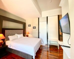 1 dormitorio con 1 cama y TV de pantalla plana en The Boone Resort, en Ban Mae Hom
