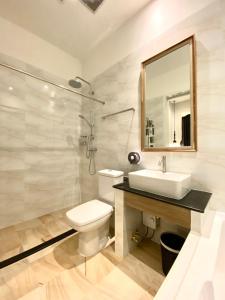 y baño con lavabo, aseo y espejo. en The Boone Resort, en Ban Mae Hom