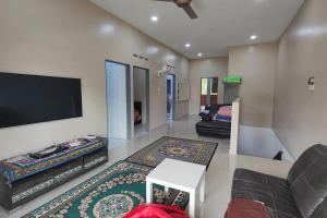 a living room with a flat screen tv and a couch at Homestay D Paya Jauh in Temerloh