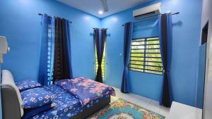 a blue room with a bed and a window at Homestay D Paya Jauh in Temerloh