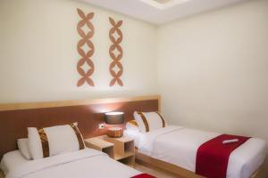 Llit o llits en una habitació de Mawar Asri Hotel
