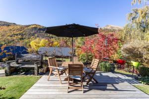a table and chairs with an umbrella on a patio at Elevated two bedroom apartment in Arrowtown