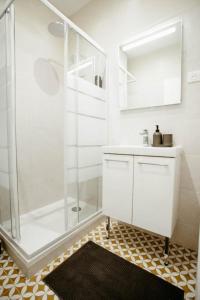 baño blanco con ducha y lavamanos en Cosy Appart hôtel Next to Paris, en Montreuil