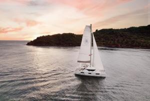 a small white sailboat on a body of water at Regent Phu Quoc in Phú Quốc