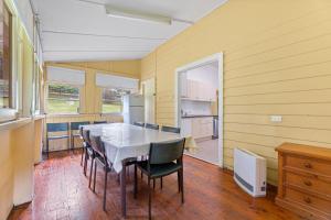 a dining room with a table and chairs at The Seamist Cottage in Narooma
