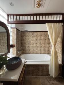 a bathroom with a tub and a sink at Camellia Residence Hanoi in Hanoi