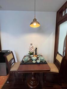 a dining room table with plates and flowers on it at Camellia Residence Hanoi in Hanoi