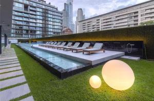 a row of benches sitting in the grass next to a pool at Mono ambiente de NIVEL in Buenos Aires