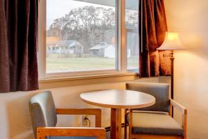 a room with a table and chairs and a window at Gale River Motel in Franconia