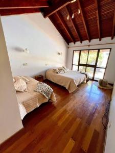 2 Betten in einem Zimmer mit Holzböden und Fenstern in der Unterkunft Gran casa corazón de Mendoza in Mendoza + 39 Fotos