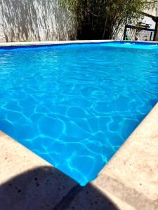 einen Pool mit blauem Wasser und einem Wasserfall in der Unterkunft Gran casa corazón de Mendoza in Mendoza