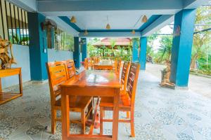 Phong Nha Green Homestay في فونغ نها: غرفة طعام مع طاولة وكراسي خشبية