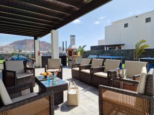 a patio with chairs and tables on a roof at VILLA KARLA in Playa Blanca