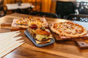 een tafel met twee pizza's en een broodje en een pizza bij Outback Motel Mt Isa in Mount Isa