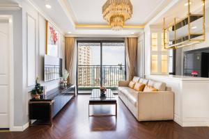 a living room with a couch and a chandelier at TeeUp Home - Infinity Pool Signature in Ho Chi Minh City