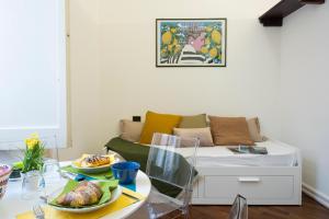 ein Wohnzimmer mit einem Sofa und einem Tisch mit Tellern. in der Unterkunft Bella Domus Suites in Salerno