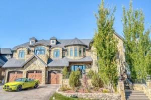 a yellow car parked in front of a large house at French Château w/Swim Spa & Theatre: 11,700 sqft in Calgary