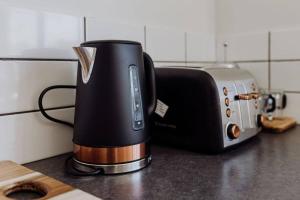 une cafetière assise sur un comptoir à côté d'un grille-pain dans l'établissement Bask - Family Friendly Home, à Bicheno