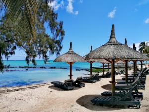 a beach with chairs and umbrellas and the ocean at Wonders Beach Boutique Hotel in Mont Choisy