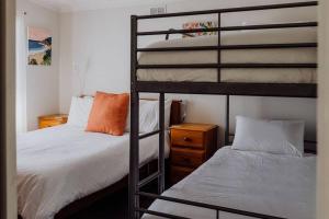 a bedroom with two bunk beds and a bed at Bask - Family Friendly Home in Bicheno