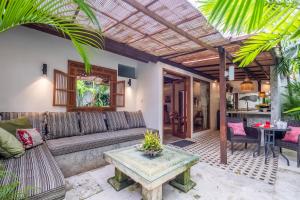 a living room with a couch and a table at Baby Melon Villas in Seminyak