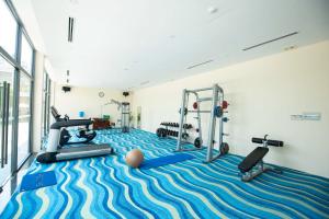 una palestra con tapis roulant e pesi su un tappeto blu e bianco di CostaBella Resort Nha Trang a Nha Trang
