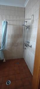 a bathroom with a shower with a tiled floor at Birch Motel Tocumwal in Tocumwal