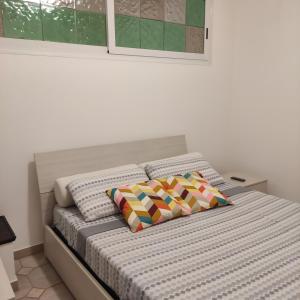 un letto con due cuscini sopra in una camera da letto di La Casa di Ari vicinissimo ospedale GASLINI GENOVA a Genova