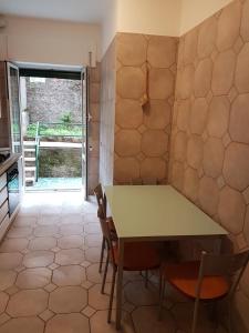 una cucina con tavolo e sedie in una stanza di La Casa di Ari vicinissimo ospedale GASLINI GENOVA a Genova