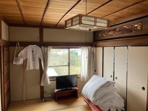 a bedroom with a bed and a tv and a window at Guest house my home 