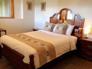 een slaapkamer met een groot bed met een houten hoofdeinde bij Ocean's Edge Suite in Campbell River