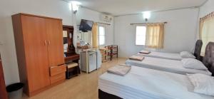 a room with three beds and a cabinet and a kitchen at Baan Pordee Homestay in Phayayen