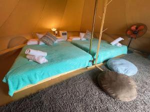 two beds in a tent with pillows on them at Rembulan Escape - beachfront bell tent (no 2) in Kampung Penarik