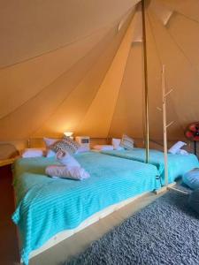 a person laying on a bed in a tent at Rembulan Escape - beachfront bell tent (no 2) in Penarek