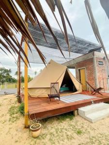 a tent on a deck in front of a building at Rembulan Escape - beachfront bell tent (no 2) in Penarek