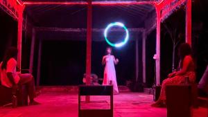 a woman in a dress on a stage with a spotlight at HostelExp, Gokarna - A Slow-Paced Backpackers Community in Gokarna