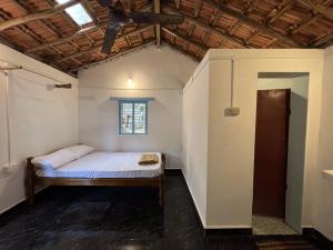 a bedroom with a bed in a room with a ceiling at HostelExp, Gokarna - A Slow-Paced Backpackers Community in Gokarna