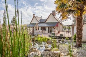 a house with a pond in front of it at Villa de 5 chambres avec piscine privee jardin clos et wifi a Bourre a 4 km de la plage in Bourré