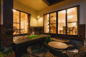 a porch with a wooden table and chairs and windows at 森の香 in Matsue