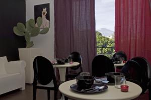 a dining room with tables and chairs and a window at Eh13 Luxury Accommodation in Catania