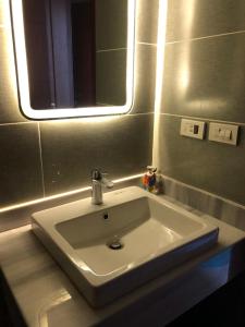 lavabo blanco en el baño con espejo en Ain Sokhna 'Cosmopolitan'- Half-Board, en Ain Sokhna