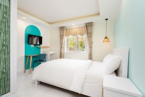 頭頓的住宿－Sunset Bãi Dâu Boutique Hotel Vũng Tàu，卧室配有白色的床和窗户。