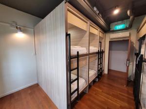 einen Flur mit Etagenbetten in einem Zimmer mit Holzböden in der Unterkunft Wink at Upper Cross Street in Singapur