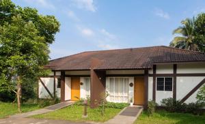 een huis met een bruin dak bij Jeevess Ayurveda Resort in Wayanad