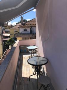 un balcone con 2 tavoli e 2 sgabelli. di Alojamento Mercado Sul a Lisbona