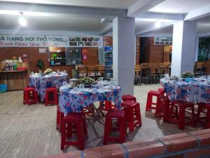 a group of tables and red chairs with blue table cloth at FOREST BREATH ECO-LODGE in Tân Phú