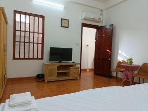 ブンタウにあるAnn Homestay Vũng Tàuのベッドルーム(ベッド1台、テーブル上のテレビ付)