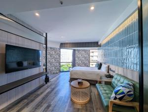 a bedroom with a bed and a couch and a tv at K Hotel - Yizhong in Taichung