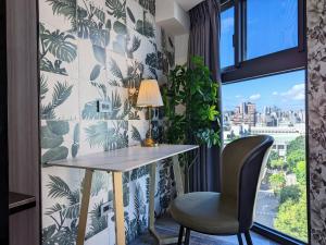 a desk and a chair in a room with a window at K Hotel - Yizhong in Taichung